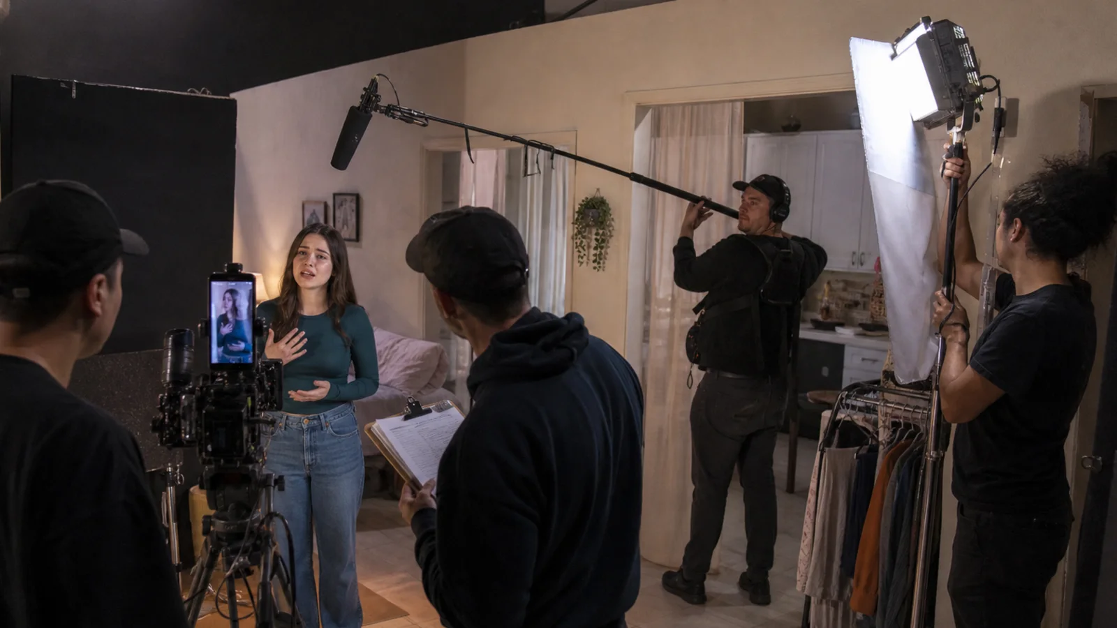 Documentary editorial visual of performer, director, sound and lighting crew working on a small Los Angeles vertical-drama set